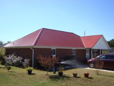 Red, bricked house with cinnamon rib roofing