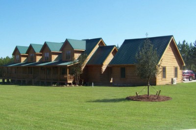 Log home with a forest green rib roofing